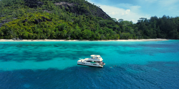 Catamaran au mouillage devant une plage tropicale des Seychelles